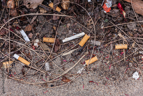 cigarette butts and litter with dirt on side of street