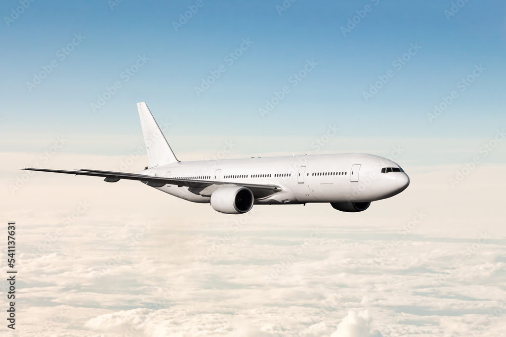 White wide body passenger airliner fly in the air above the clouds