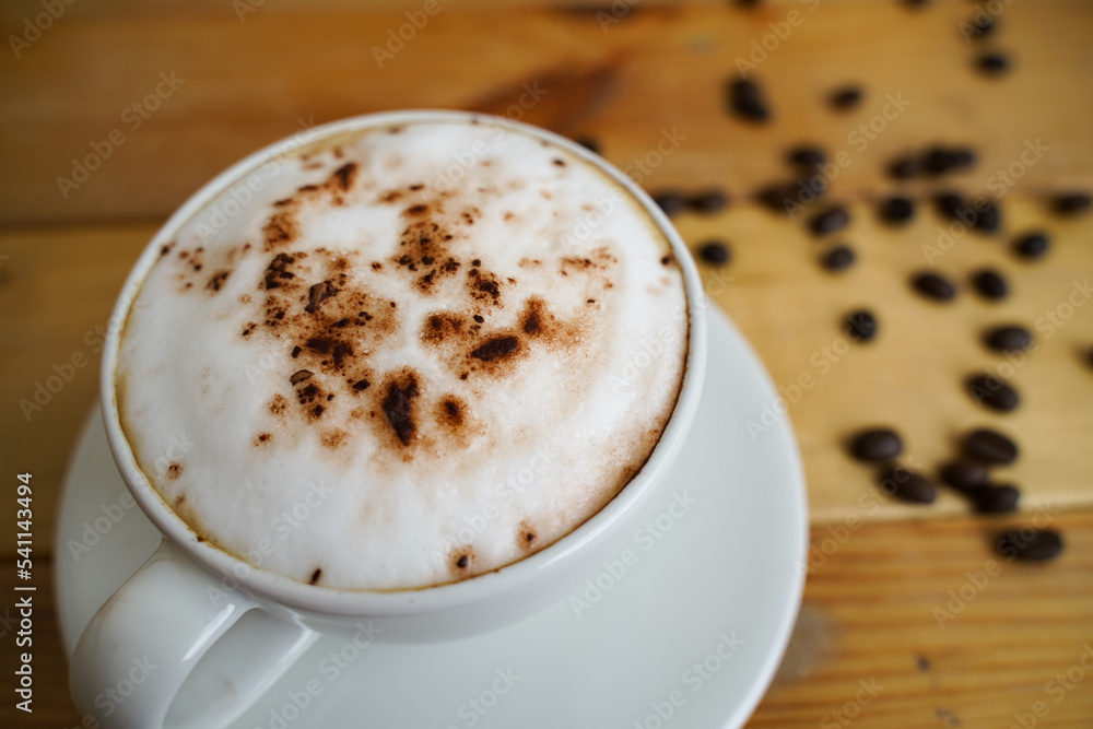 Hot cappuccino in white cup with wooden background,coffee is a popular drink all over the world. Hot cappuccino in white cup with wooden background,coffee is a popular drink all over the world.