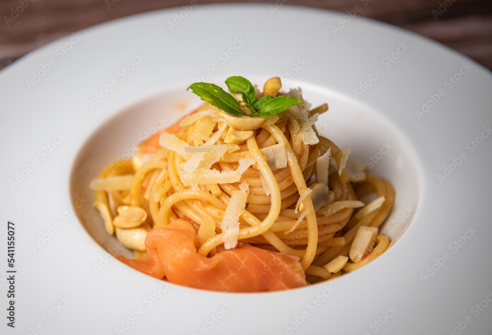 Recipe for homemade spaghetti with tomato sauce, smoked salmon, roasted peanuts and parmesan. High quality photo