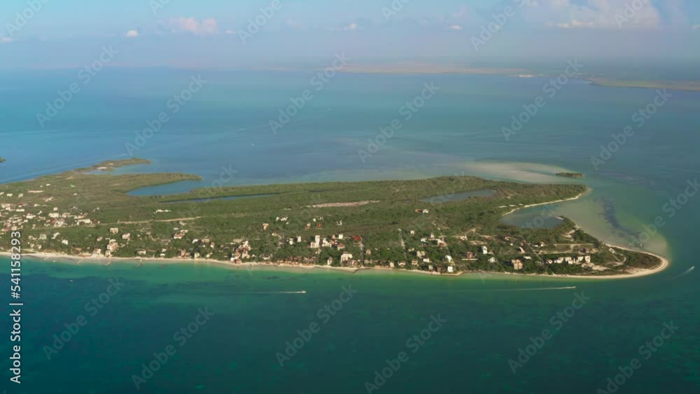 Aerial flight along exotic island with cruising boats and small villages on Holbox Island during sunny day Aerial flight along exotic island with cruising boats and small villages on Holbox Island during sunny day