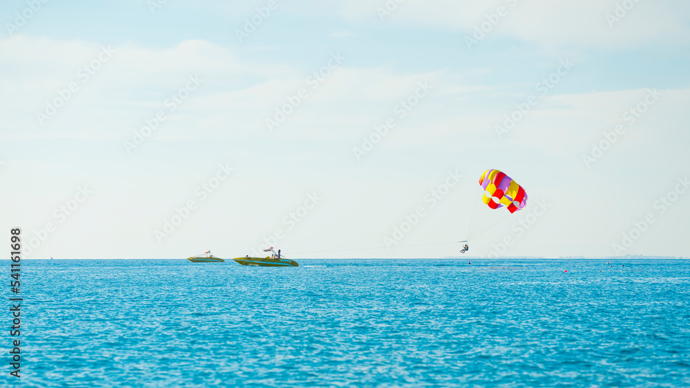 magnificent view of colorful parasail wing pulled by a boat in the bright blue sea, Alanya, Turkey. High quality photo