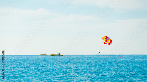 magnificent view of colorful parasail wing pulled by a boat in the bright blue sea, Alanya, Turkey. High quality photo
