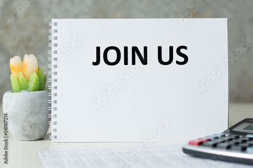 Join Us text on sticky note with a business objects.