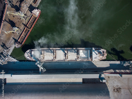 Aerial view of big cargo ship bulk carrier is loaded with minerals in port