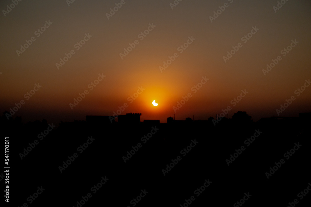 October 25th 2022 Dehradun City, Uttarakhand India. Partial Solar Eclipse in th evening with cityscape.