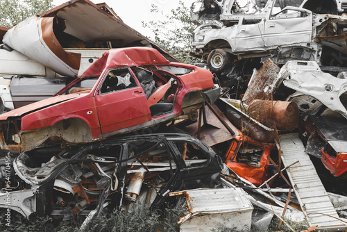 Scrap car recycle yard. Stacked crushed cars going to be shredded in a recycling facility.