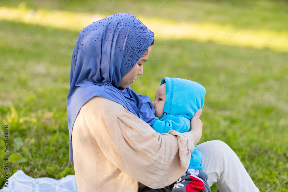 breast feeding concept. young islamic woman hugging newborn baby boy in