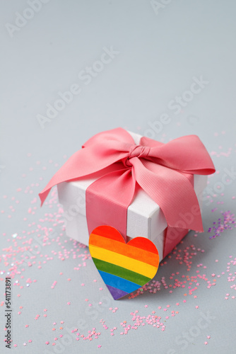 Stylish luxury gift box with rainbow LGBT heart on a light gray table. Homosexual and lgbt concept of holiday, birthday, valentine day, banner, flyer, innvitation photo