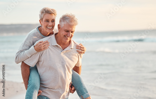 Fototapeta Love, beach and piggyback with a senior couple walking by the sea or ocean while on a date in summer together