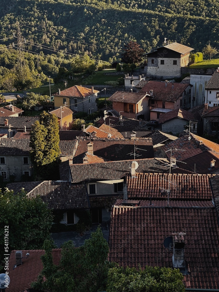 Top view of red tile roofs of traditional ancient Italian mountain village. Travel concept. Alpine old town with vintage buildings