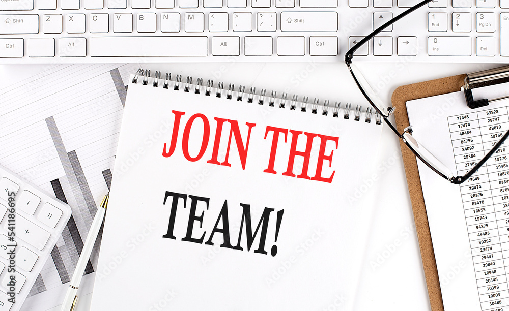 Text JOIN THE TEAM on Office desk table with keyboard, notepad and analysis chart on white background. Text JOIN THE TEAM on Office desk table with keyboard, notepad and analysis chart on white background.