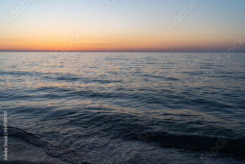 Sunset sky reflecting in the water  aerial view from the sandy shore.Travel destinations  vacations concept. Vacation holiday banner. Meditation ocean and panoramic beach landscape