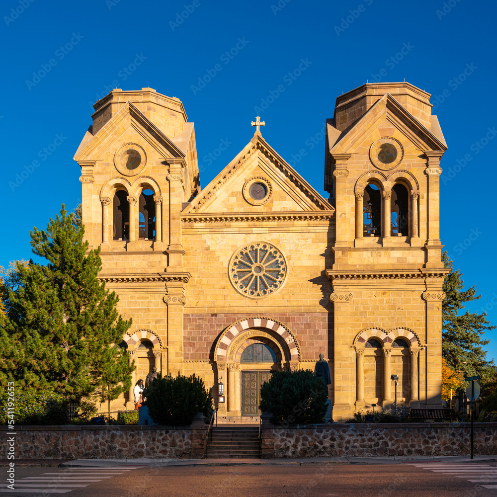 Fototapeta premium The facade of Cathedral Basilica of St. Francis of Assisi illuminated by the sun rays in Santa Fe, the capital of New Mexico