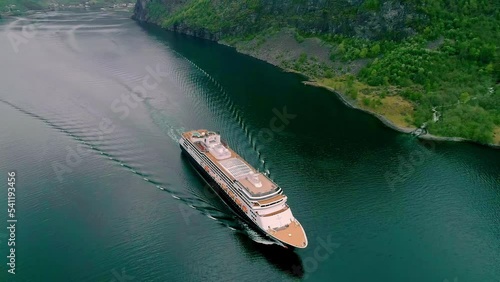 Aerial drone bird's eye view over giant cruise ship in motion along Norwegian Fjord in Flam, Norway on a cloudy day. photo