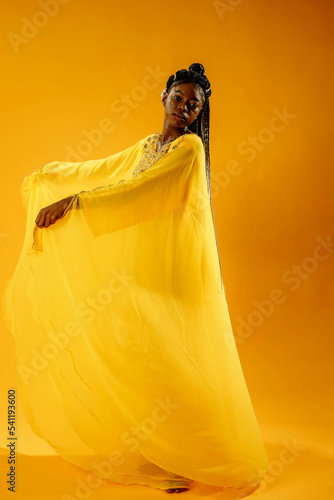 a girl in a yellow dress on a yellow backgrou