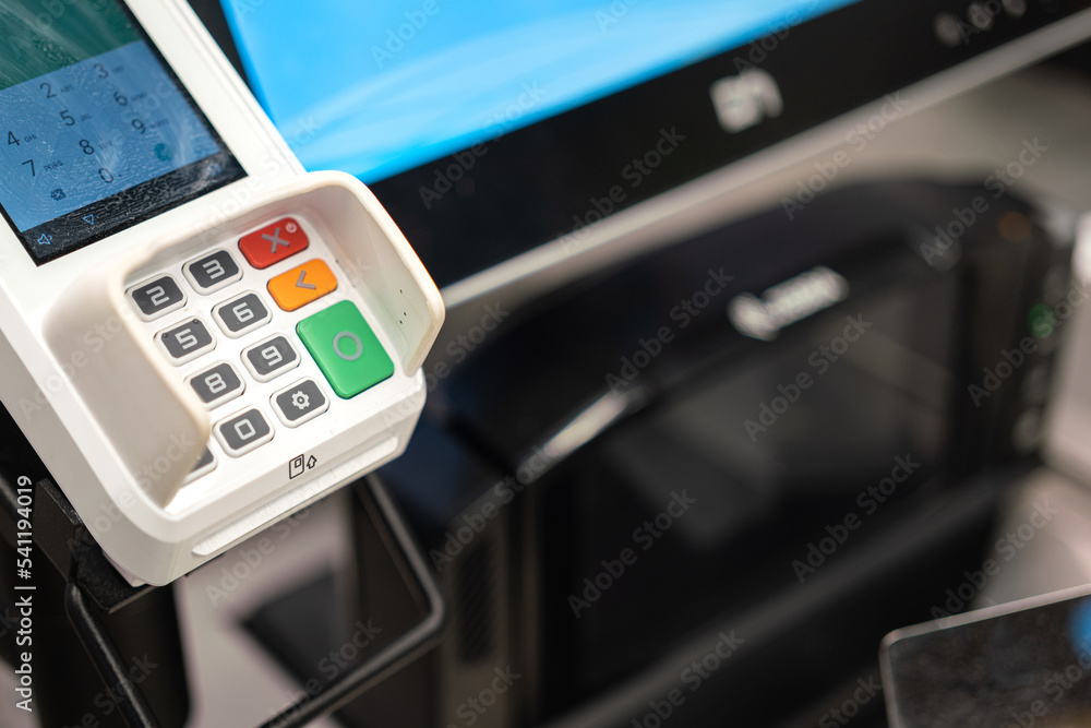 A credit card reader machine at the payment cashier. Financial technology device object photo, selective focus on the number keypad. A credit card reader machine at the payment cashier. Financial technology device object photo, selective focus on the number keypad.