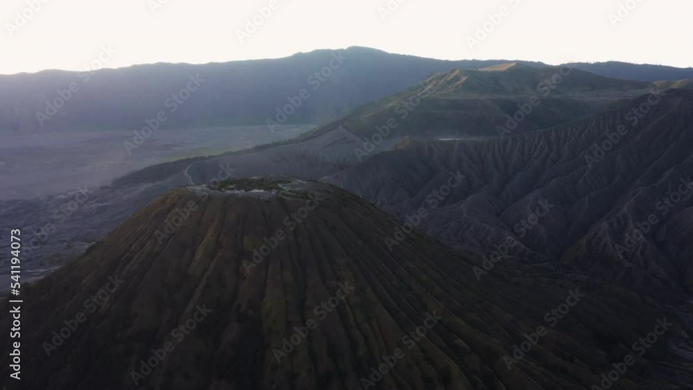 View from above, stunning aerial view of the Mount Batok and the Mount Bromo illuminated at sunset. Mount Bromo is an active volcano in East Java, Indonesia. View from above, stunning aerial view of the Mount Batok and the Mount Bromo illuminated at sunset. Mount Bromo is an active volcano in East Java, Indonesia.