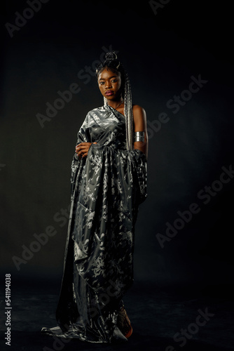 a girl in a black dress with a pattern on a black background