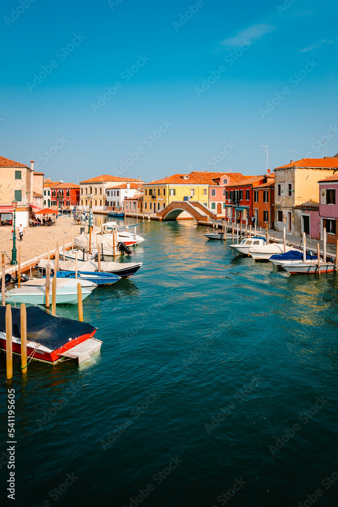 Typical Murano canal with colorful houses and moored boats