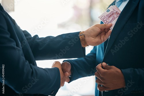 Handshake, money and bribery deal between businessmen in partnership in a corporate company office. Corruption, money laundering and illegal employees in a corrupt crime agreement bribe in workplace. photo