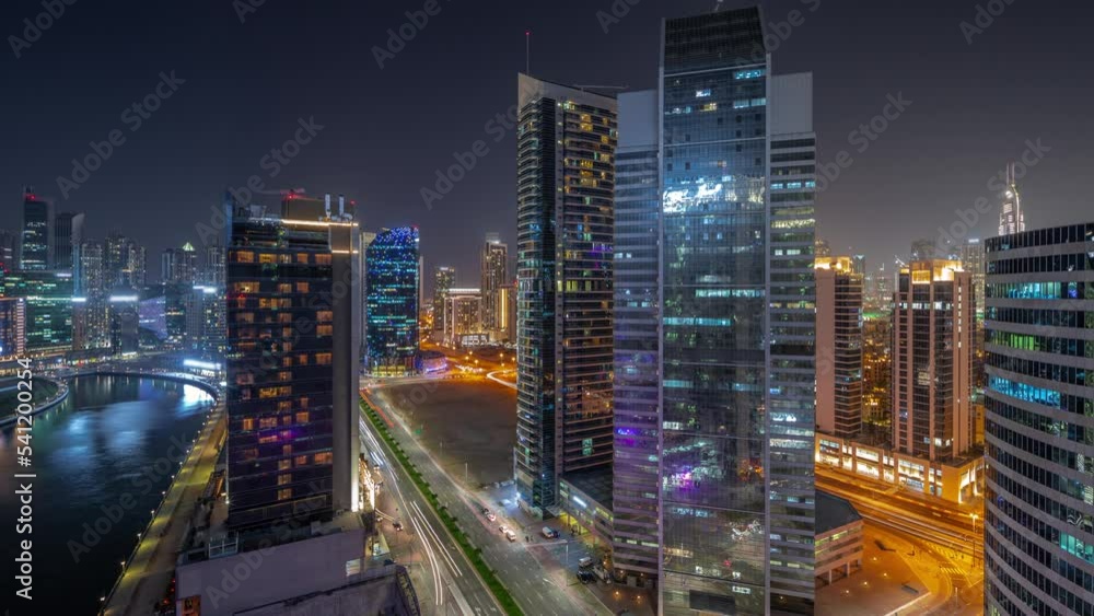 Cityscape of skyscrapers in Dubai Business Bay and downtown with water canal aerial day to night transition timelapse. Modern skyline with towers and waterfront after sunset. A center of international Cityscape of skyscrapers in Dubai Business Bay and downtown with water canal aerial day to night transition timelapse. Modern skyline with towers and waterfront after sunset. A center of international