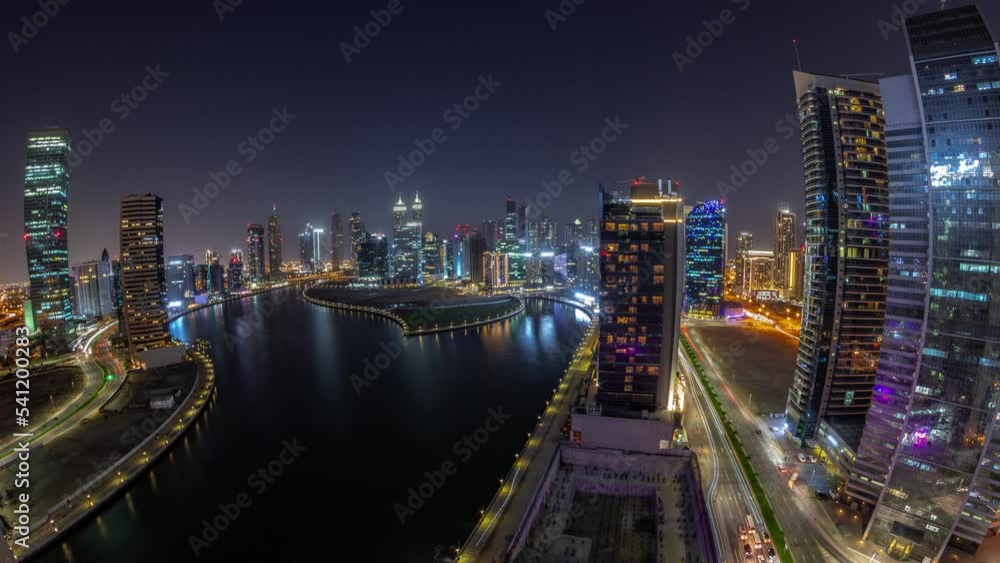 Cityscape panorama of skyscrapers in Dubai Business Bay with water canal aerial day to night transition timelapse. Modern skyline with towers and waterfront after sunset. A center of international Cityscape panorama of skyscrapers in Dubai Business Bay with water canal aerial day to night transition timelapse. Modern skyline with towers and waterfront after sunset. A center of international