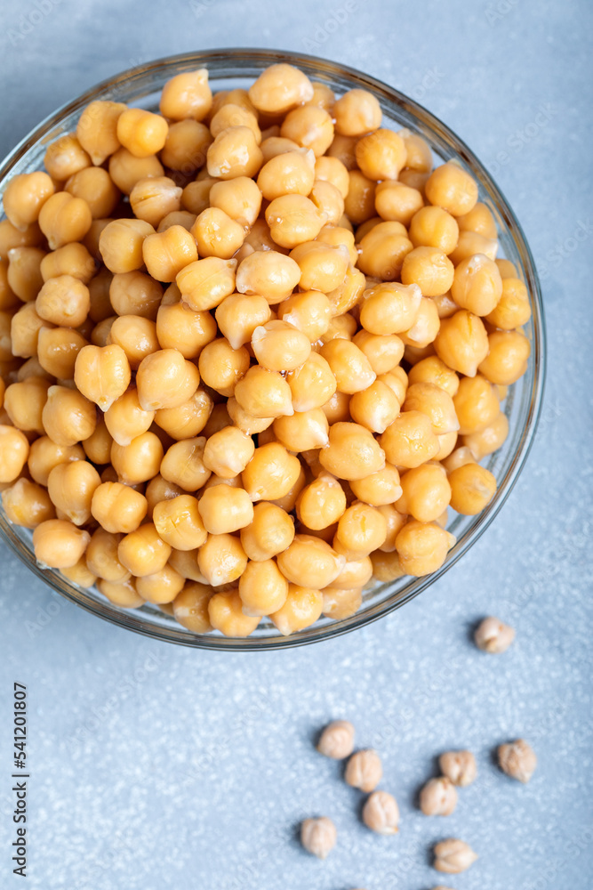 Boiled chickpeas in a glass bowl on a gray background. Top view. Boiled chickpeas in a glass bowl on a gray background. Top view.