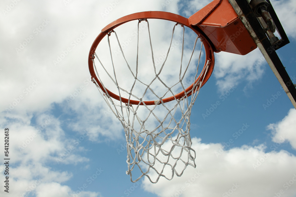 basketball hoop with its net under a blue sky basketball hoop with its net under a blue sky