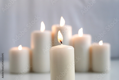 Large burning wax candles on a white background.