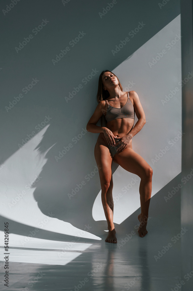 Fototapeta premium Sportive body type. Young woman in underwear is in the studio