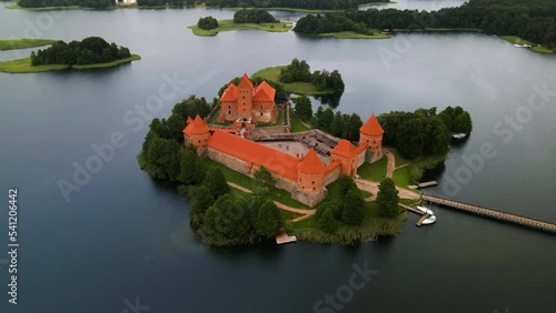 An aerial shot of the Trakai castle, medieval gothic Island castle,  surrounded by green trees over the Galves lake in Trakai, Lithuania photo