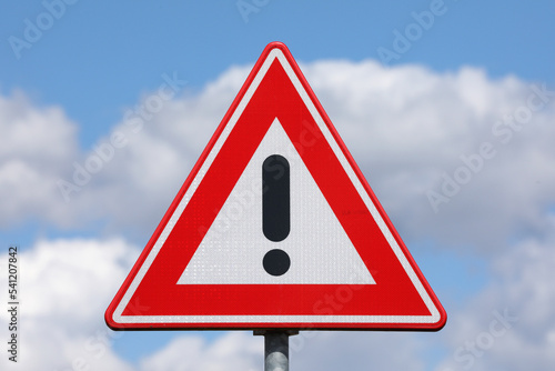 A sign with a exclamation mark warning for a dangerous situation ahead 