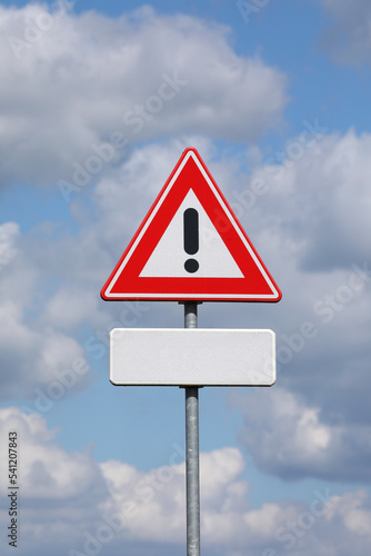 A sign with a exclamation mark warning for a dangerous situation ahead. At the bottom a smaller sign on which an editor can place a text 