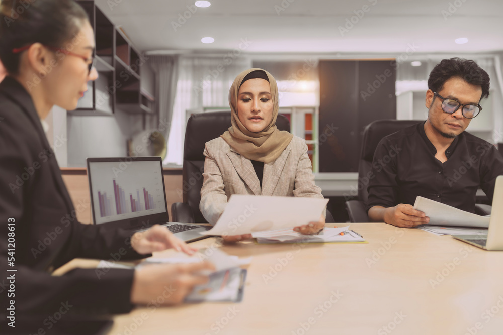 business muslim and asian woman and man have meeting. diversity people with asian woman and man and hijab person having a conversation about project at workplace. in conference room people is debate business muslim and asian woman and man have meeting. diversity people with asian woman and man and hijab person having a conversation about project at workplace. in conference room people is debate