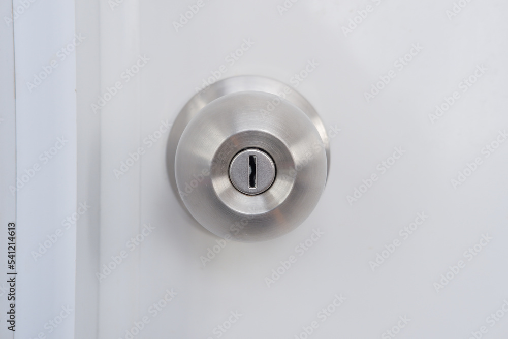 Close-up of a silver doorknob mounted on a white door. Close-up of a silver doorknob mounted on a white door.
