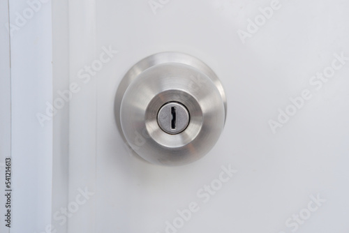 Close-up of a silver doorknob mounted on a white door.