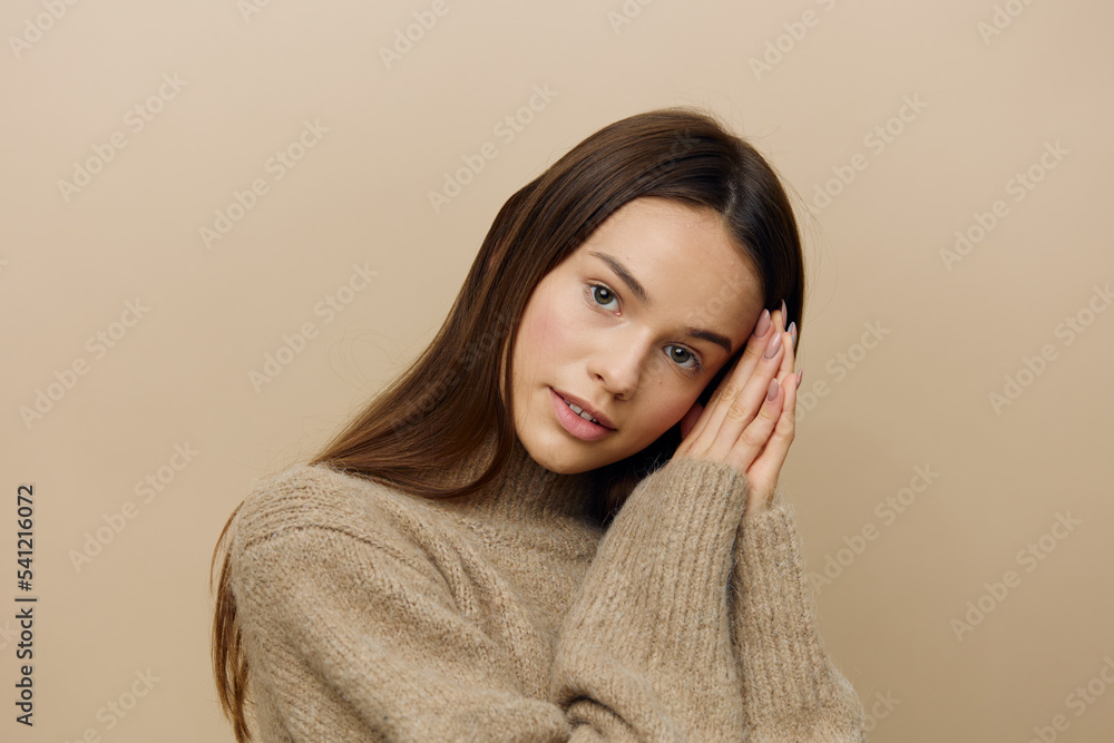 a refined, gentle woman in a textured, warm sweater looks pleasantly into the camera with her palms folded near her head in a gentle relaxed gesture a refined, gentle woman in a textured, warm sweater looks pleasantly into the camera with her palms folded near her head in a gentle relaxed gesture