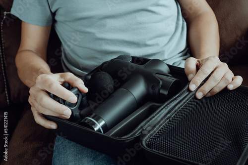 man about to takes a massage gun out of its case