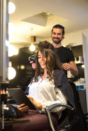 Young woman getting new hairstyle from hairdresser in the modern hair salon