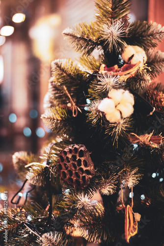 Fir branch with eco friendly organic decor and festive lights on the Christmas background with sparkles. New Year's composition Merry Christmas! Happy New Year! Copy Space photo