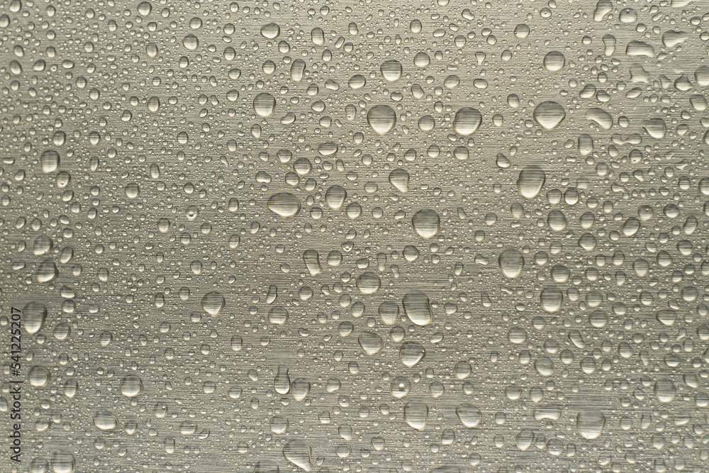 Raindrops on the chrome-plated metal surface. Rain on a metallic silver background. Raindrops on the chrome-plated metal surface. Rain on a metallic silver background.