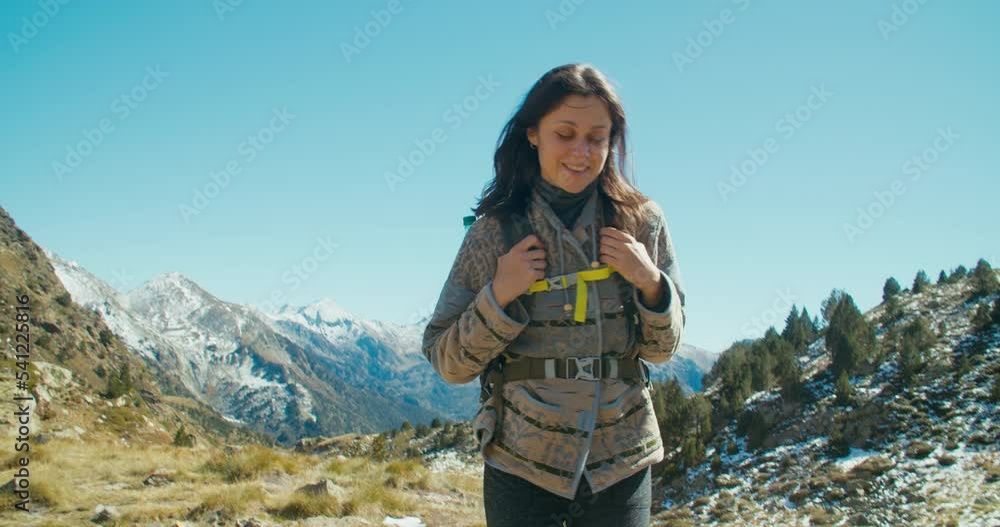 Contented female traveller walk on beautiful mountain landscape with backpack Contented female traveller walk on beautiful mountain landscape with backpack