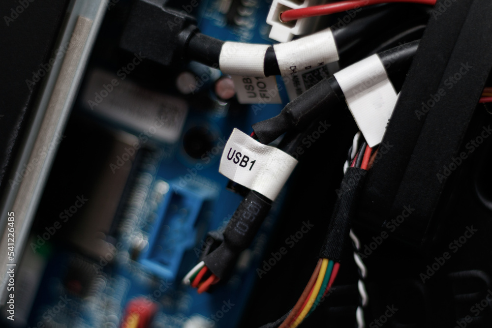 Close up on electronic components of a modern gaming computer. Colored cables are visible. Focus on a white label indicating Close up on electronic components of a modern gaming computer. Colored cables are visible. Focus on a white label indicating