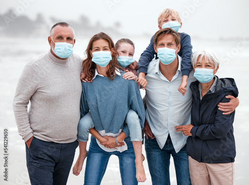 Covid, family and ocean portrait with children in Germany with corona virus protection mask. Love, care and big family bonding at beach with coronavirus face mask for safety of grandparents.