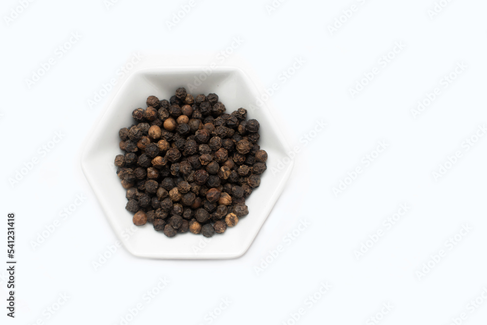 minimalist concept of natural black pepper spice on white hexagon-shaped plate minimalist concept of natural black pepper spice on white hexagon-shaped plate