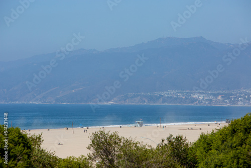 Malibu Beach View with Ocean, Village, Sand, and Mountain Zoomed by Telephoto Lens on Sunny Bright Day