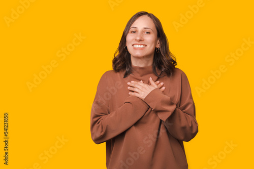 How sweet and cute, young beautiful woman holding palms together over chest and gesturing