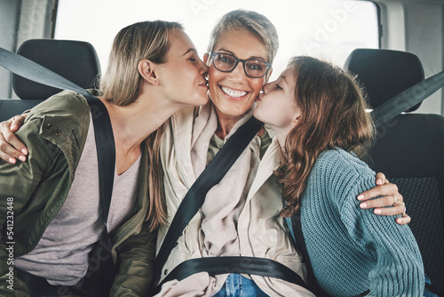 Fotografi Family, children and road trip with a girl, mother and grandmother kissing in the backset of a car