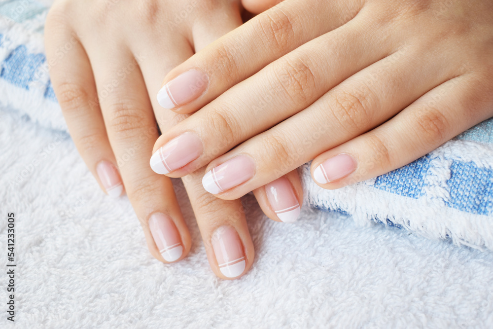 Hand and nail care with French style manicure with white polish